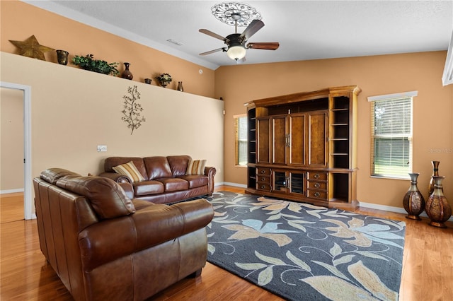 living room featuring wood-type flooring, lofted ceiling, and ceiling fan