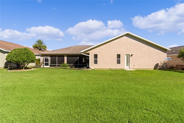 back of house featuring a yard and a sunroom