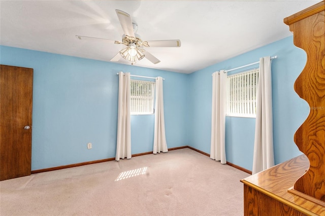 spare room with ceiling fan and light carpet