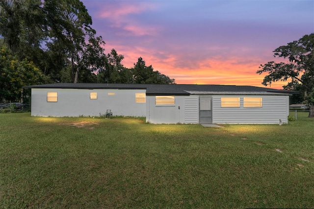 back house at dusk with a yard