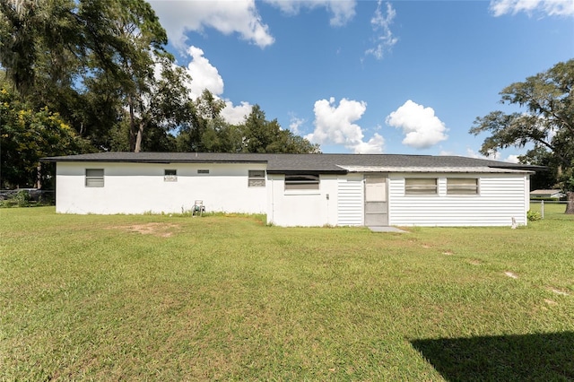 rear view of property featuring a yard