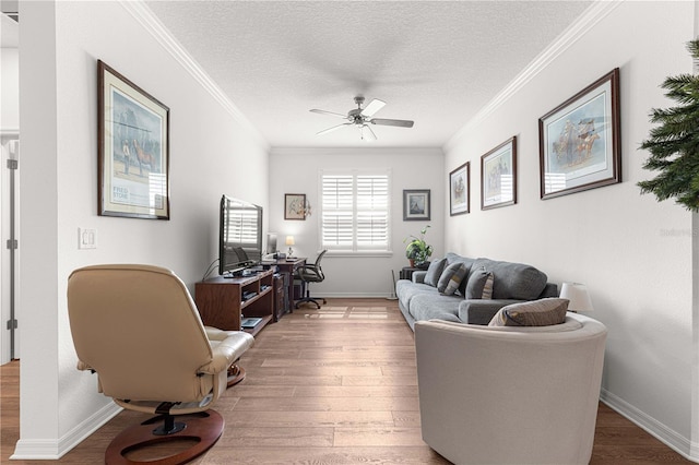 living room featuring ornamental molding, ceiling fan, hardwood / wood-style flooring, and a textured ceiling