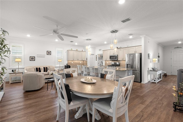 dining room with ornamental molding, a textured ceiling, ceiling fan with notable chandelier, and dark wood-type flooring