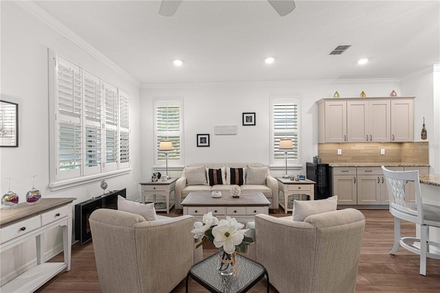 living room featuring ornamental molding, dark hardwood / wood-style floors, ceiling fan, and a wealth of natural light