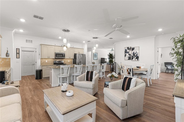 living room with ceiling fan, light wood-type flooring, and crown molding