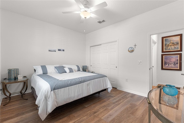 bedroom featuring a closet, dark hardwood / wood-style floors, and ceiling fan