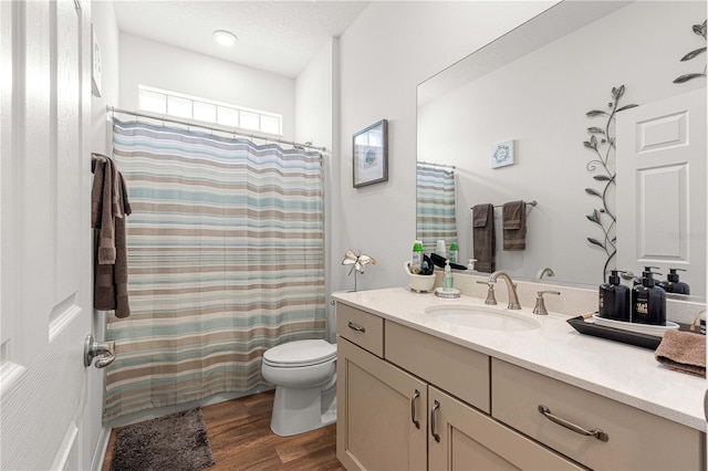 bathroom featuring hardwood / wood-style floors, a textured ceiling, vanity, and toilet