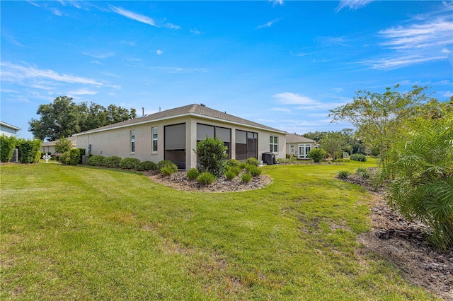 view of side of property featuring a yard and central AC unit