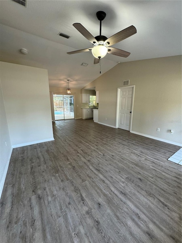 unfurnished living room with ceiling fan, dark wood-type flooring, and vaulted ceiling