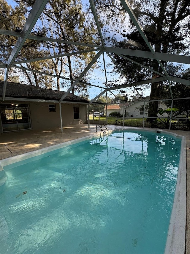 view of swimming pool with glass enclosure and a patio area