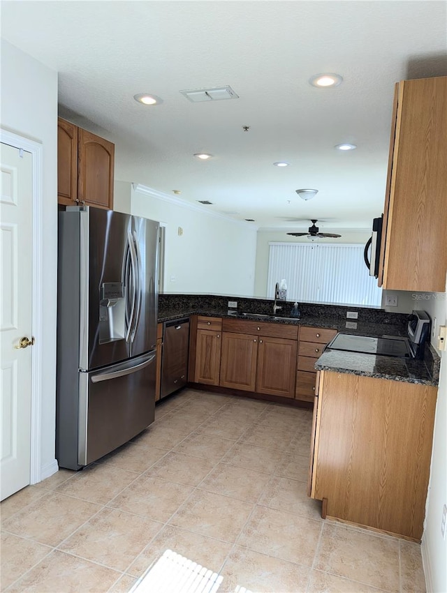 kitchen featuring appliances with stainless steel finishes, sink, ceiling fan, dark stone countertops, and light tile patterned floors