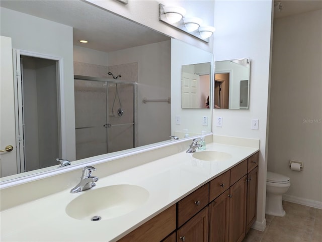 bathroom with toilet, tile patterned flooring, vanity, and a shower with door