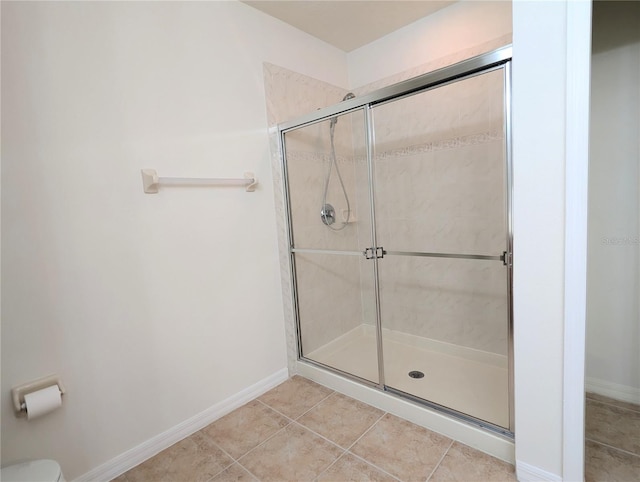 bathroom with toilet, tile patterned flooring, and an enclosed shower