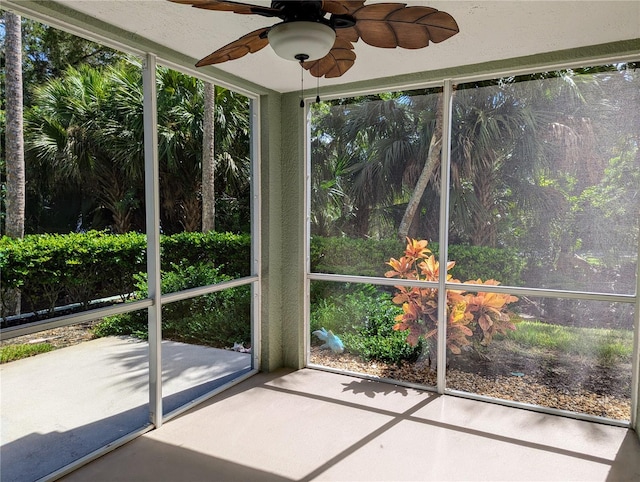 unfurnished sunroom featuring ceiling fan