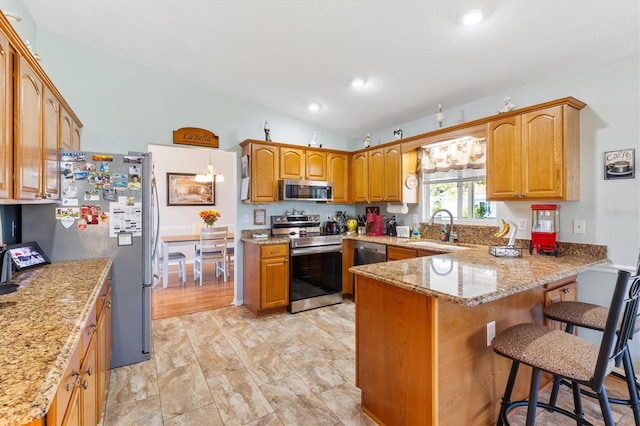 kitchen with a breakfast bar area, vaulted ceiling, sink, kitchen peninsula, and appliances with stainless steel finishes