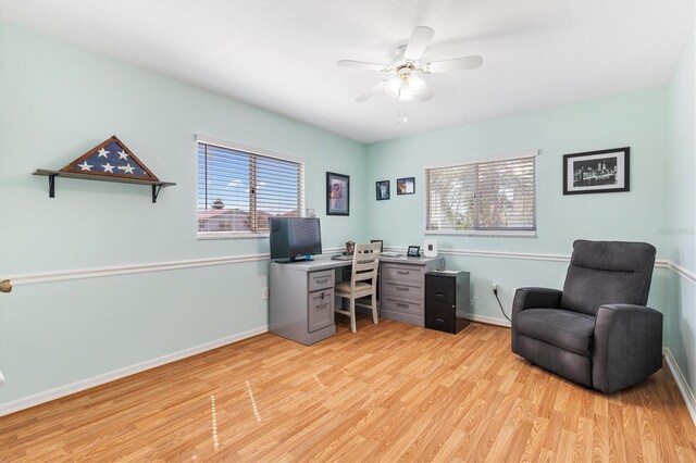 home office with light hardwood / wood-style flooring, a wealth of natural light, and ceiling fan