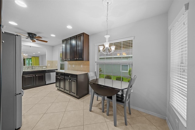 kitchen featuring appliances with stainless steel finishes, decorative backsplash, light tile patterned floors, dark brown cabinets, and sink