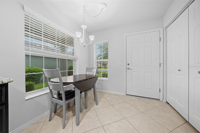 tiled dining room featuring an inviting chandelier