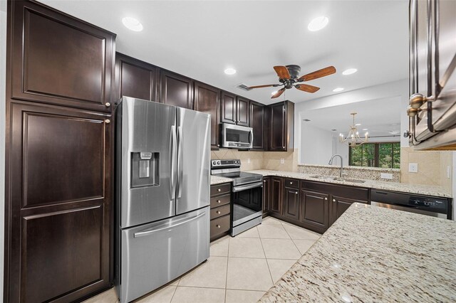 kitchen featuring light stone counters, tasteful backsplash, light tile patterned floors, stainless steel appliances, and sink