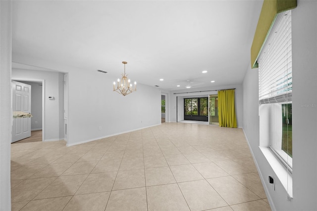 tiled empty room with a notable chandelier