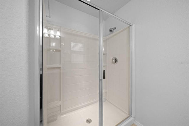 bathroom featuring a shower with shower door