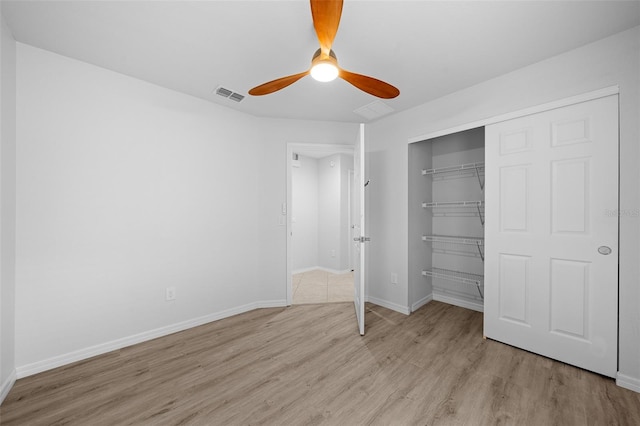 unfurnished bedroom featuring a closet, light hardwood / wood-style floors, and ceiling fan