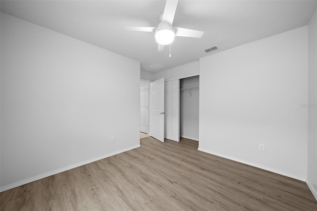 unfurnished bedroom featuring a closet, light hardwood / wood-style floors, and ceiling fan