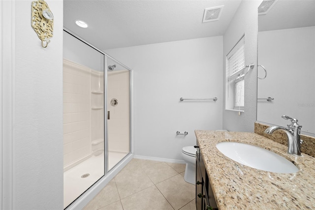 bathroom featuring tile patterned flooring, vanity, toilet, and a shower with shower door