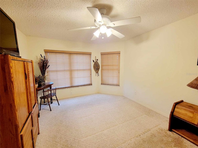 sitting room with light carpet, ceiling fan, and a textured ceiling