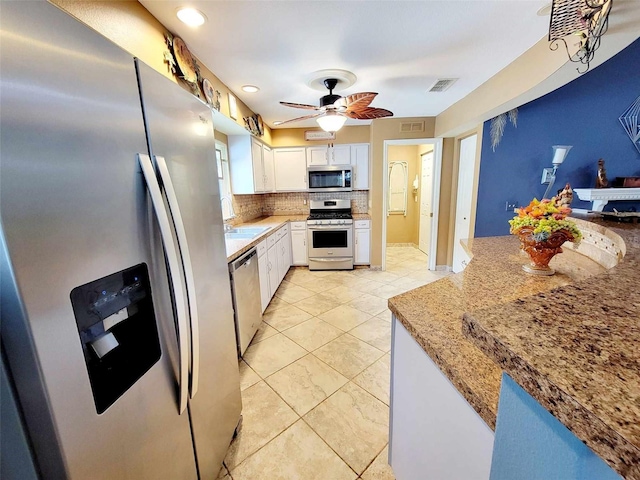 kitchen featuring light stone counters, white cabinets, sink, backsplash, and stainless steel appliances