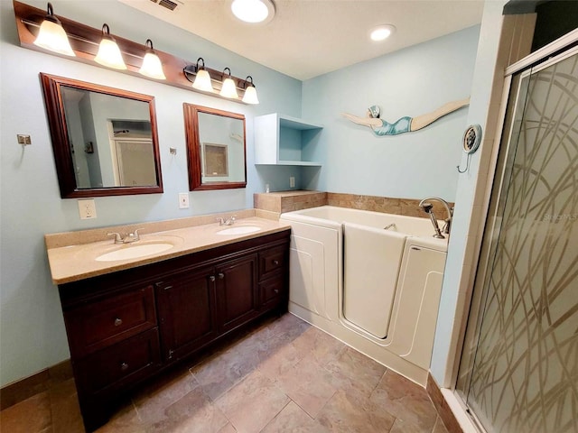 bathroom featuring vanity and independent shower and bath