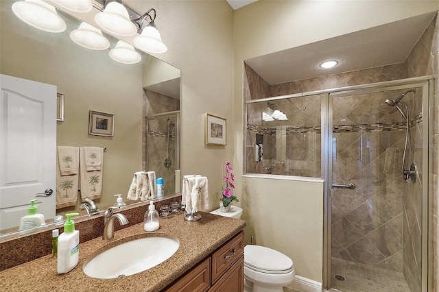 bathroom featuring vanity, toilet, and a shower with door