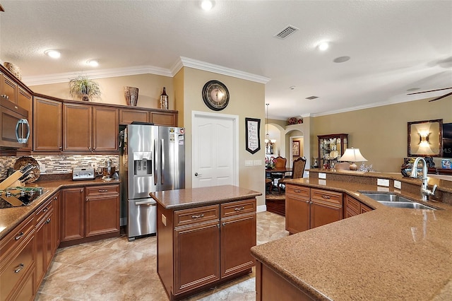 kitchen with ornamental molding, stainless steel appliances, a kitchen island, and sink