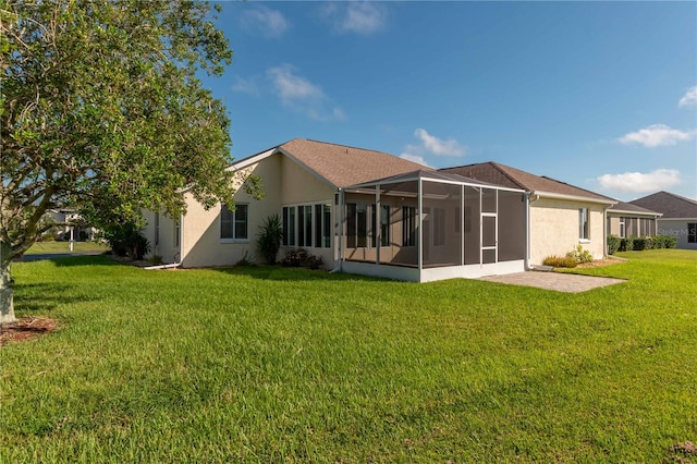 rear view of property with a yard, a sunroom, and a patio area