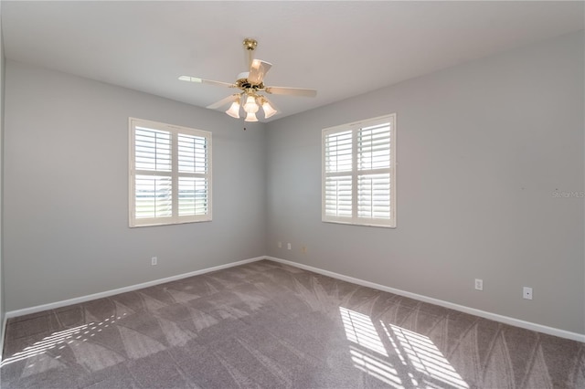 carpeted spare room with ceiling fan and a wealth of natural light