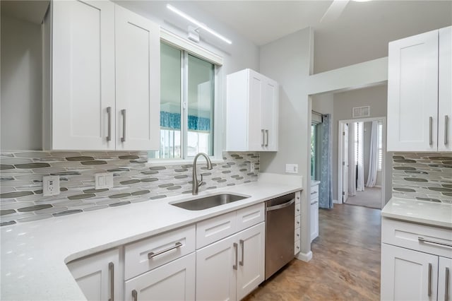 kitchen featuring backsplash, dishwasher, white cabinetry, and sink