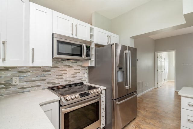 kitchen featuring decorative backsplash, stainless steel appliances, and white cabinetry