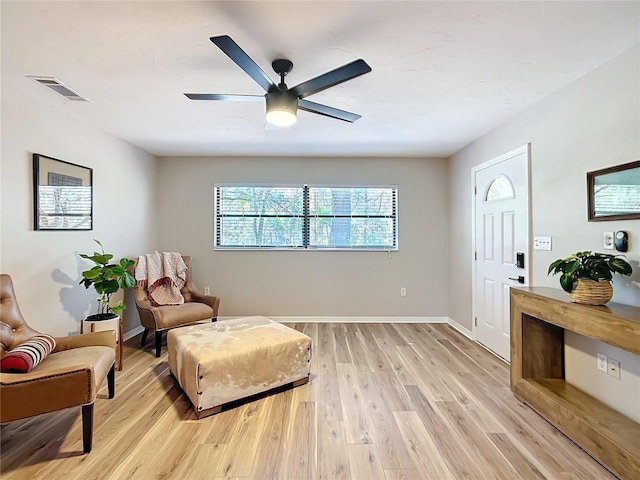 living area with ceiling fan and light hardwood / wood-style flooring