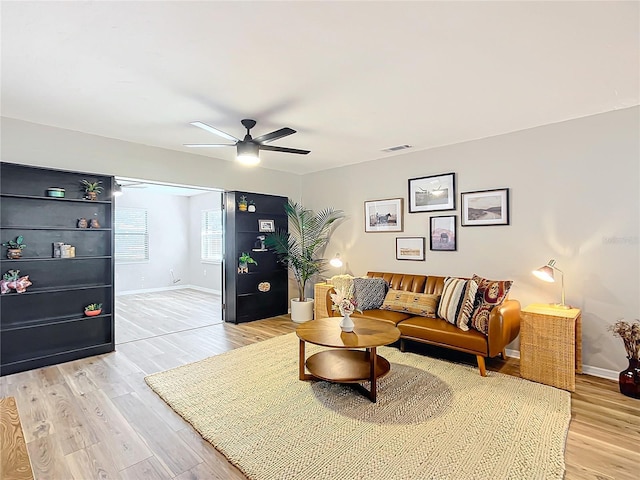 living room featuring ceiling fan and light wood-type flooring