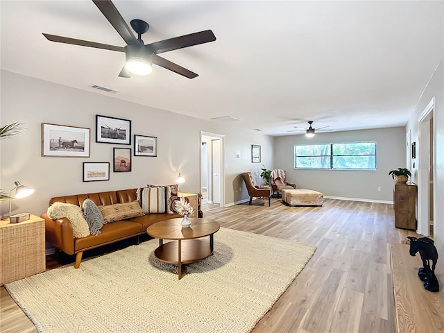 living room featuring ceiling fan and light hardwood / wood-style floors