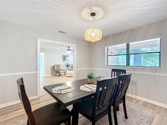 dining space with ceiling fan and light hardwood / wood-style flooring