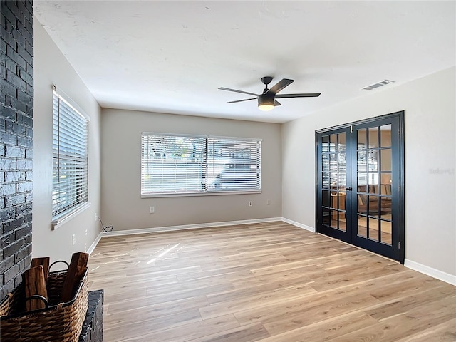 unfurnished room with ceiling fan, light hardwood / wood-style floors, and french doors