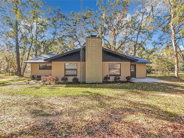 view of property exterior with a yard and a patio area