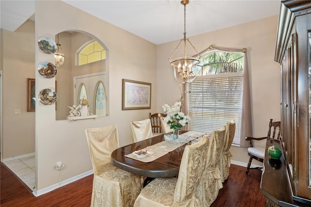 dining area featuring an inviting chandelier and dark wood-type flooring