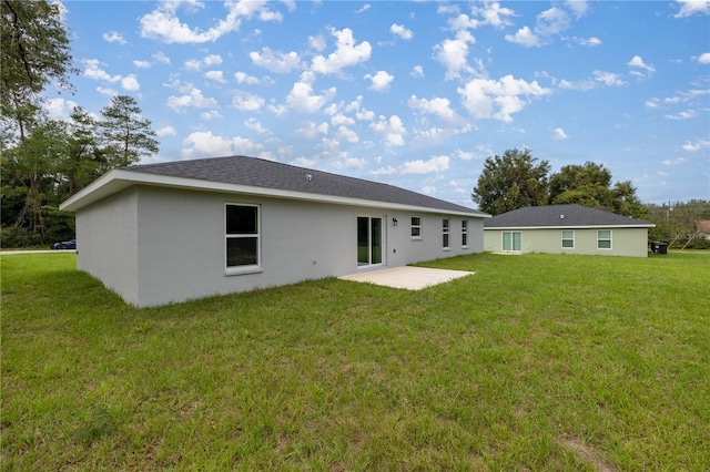 back of house with a patio area and a lawn