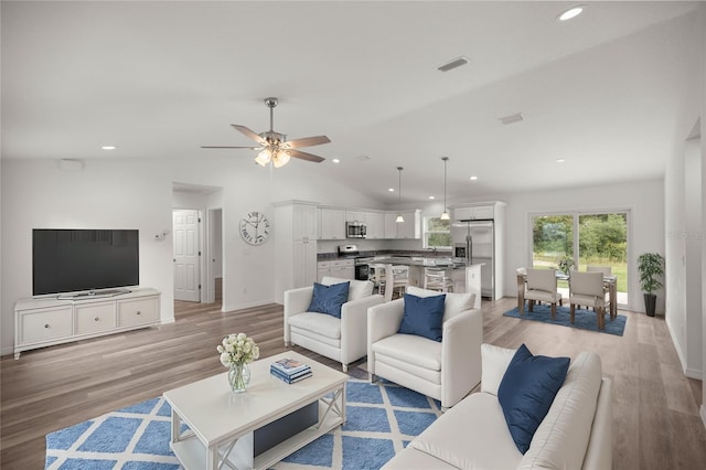 living room with vaulted ceiling, ceiling fan, and light hardwood / wood-style floors