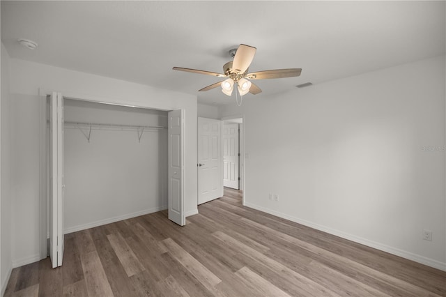 unfurnished bedroom featuring a closet, ceiling fan, and light wood-type flooring