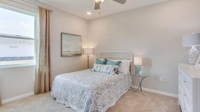 bedroom with ceiling fan and light colored carpet