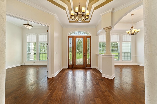 foyer with ornamental molding, dark wood-type flooring, a chandelier, and ornate columns