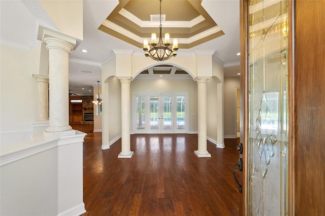 foyer featuring french doors, dark hardwood / wood-style floors, a chandelier, and ornamental molding